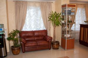 a brown leather couch sitting in front of a window at Europa Hotel in Noyabrsk