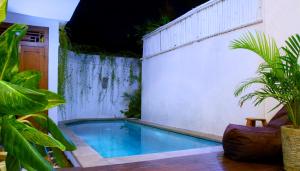 a swimming pool in a backyard with plants at Villa Sammy in Seminyak