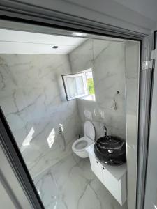 a white bathroom with a toilet and a sink at Oli House 3 in Durrës