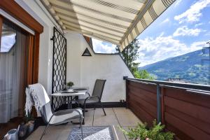 a patio with a table and chairs on a balcony at Winzig Apartment in Schladming