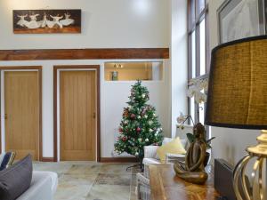 Un árbol de Navidad en una sala de estar con un sofá. en Hendre Barn Mawr, en Abergynolwyn