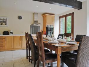 Un comedor con mesa y sillas de madera. en Hendre Barn Mawr, en Abergynolwyn