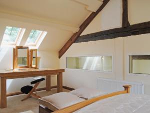 Un dormitorio con una cama, un escritorio y ventanas. en Hendre Barn Mawr, en Abergynolwyn 13 fotos más