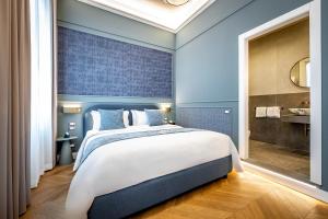 a bedroom with a large bed and a bathroom at Dimora Collection - Le Logge - Historic Boutique Luxury Suites in Florence