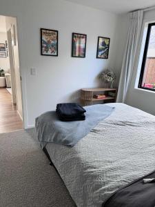 a bed with a black bag sitting on top of it at One bedroom apartment in Queenstown Airport