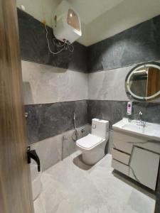 a bathroom with a toilet and a sink and a mirror at Hotel Godbless in Vrindāvan +3 photos