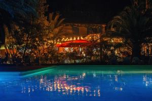 a swimming pool at night with a restaurant in the background at Camping la Peiriere - Chalet & Mobile-home in Tuchan