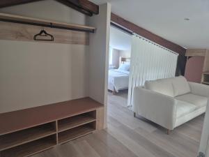 Thun-Saint-MartinにあるLa maison du Moulinのリビングルーム(白いソファ、ベッド付)