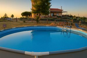 a large blue swimming pool in a yard at EuZoea Country Home 2 in Kapandrítion