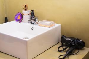 a white bathroom sink with a hair dryer and a phone at Swarna Nature Villa in Kandy