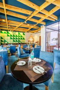 a dining room with a table and blue chairs at The SM Hotel By RMR Hotels in New Delhi