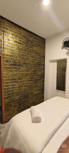 MeenangadiにあるDreaminn family Homestayのベッドと木の壁がある寝室