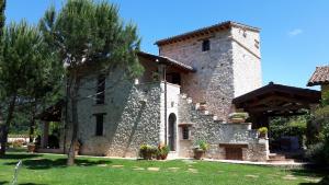 a large stone building with a tree in front of it at I Terzieri Country House in Ferentillo