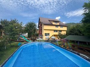 a large swimming pool in front of a building at Pensiunea Mary in Moieciu de Jos