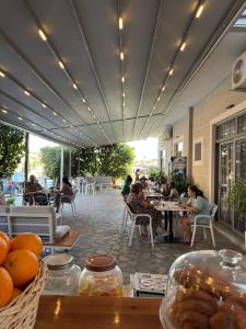 a group of people sitting at tables on a patio at Hotel LIDI in Sarandë