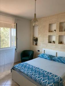 a bedroom with a bed and a green chair at Dimora Ulivo in Impalata
