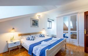 una camera bianca con un grande letto con lenzuola blu di Villa Stavros by Villas Guide a Blato Altre 40 foto