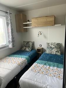 a bedroom with two beds and a window at Mobil-Home Bora-Bora in Les Mathes