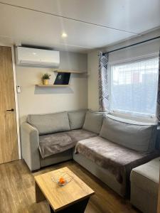 a living room with a couch and a table at Mobil-Home Bora-Bora in Les Mathes +16 photos