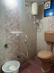 a bathroom with a toilet and a phone on the wall at Nature's Nest Homestay Tirupati close to Sri Padmavathi Ammavari Temple Tiruchanur close to toll road connecting all highways just behind Taj Tirupati and easy access to Garuda fly-over to Tirumala in Tirupati +12 photos
