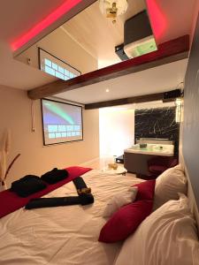 a bedroom with a large bed with red pillows at De Marbre et D or entre le futuroscope et le parc du Puy duFou in Boësse