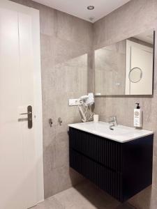 a bathroom with a sink and a mirror at Color Suites Alicante in Alicante