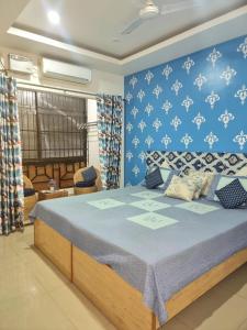 a bedroom with a bed with a blue wall at 172 LBS - A Boutique Guest House in Guwahati