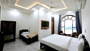 a bedroom with two beds and a desk and a window at Ranthambore Jalsa in Sawāi Mādhopur