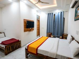 a bedroom with two beds and a tv on the wall at Ranthambore Jalsa in Sawāi Mādhopur +11 photos