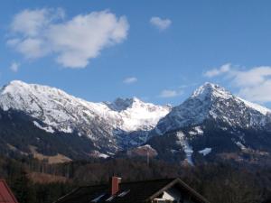 a snow covered mountain range with a house at Ferienwohnung Hutter in Fischen