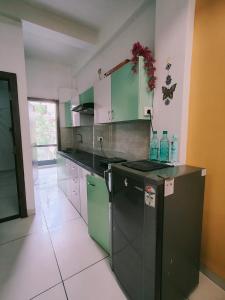 a kitchen with green cabinets and a dishwasher at Fully Private 1BHK Couple Friendly at Serene Green Entire rental unit in Indore, India in Indore +7 photos
