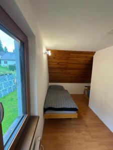 a small bed in a room with a window at Panorama House Lipno in Jenišov