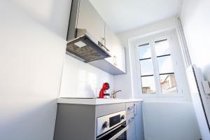 Una cocina blanca con fregadero y ventana. en Appartement Unique , rue du 14 juillet, en Le Pré-Saint-Gervais 2 fotos más