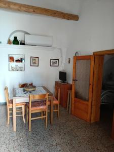 a dining room with a table and chairs and a bedroom at Trulli di nonno Ciccio in Cisternino