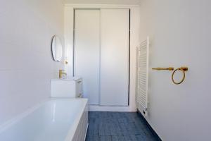 Un baño blanco con bañera y lavabo. en Appartement Unique , rue du 14 juillet, en Le Pré-Saint-Gervais