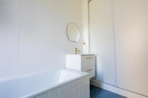 Un baño blanco con lavabo y espejo. en Appartement Unique , rue du 14 juillet, en Le Pré-Saint-Gervais