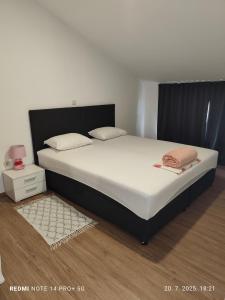 a bedroom with a large bed with white sheets and pillows at Apartmani Bezek in Ston