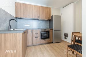 Una cocina con gabinetes de madera y un refrigerador de acero inoxidable. en Kw luxury, en Kuala Lumpur