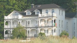 a large white house with people on the balcony at Villa Strandperle, App 04 - nur 20m zum Strand, TOPLAGE in Binz