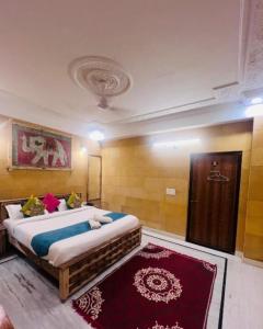 斋沙默尔Hotel Hostel Stay Jaisalmer的一间卧室配有一张大床和红色地毯。