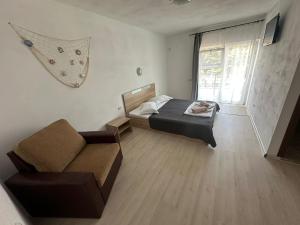 a small bedroom with a bed and a couch at Vila Cornelius in Costinesti