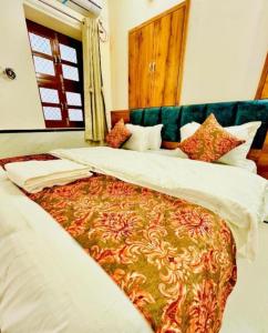 斋沙默尔Hotel Hostel Stay Jaisalmer的配有一张大床的酒店客房内的两张床