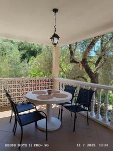 a porch with a table and chairs on a balcony at Apartmani Bezek in Ston