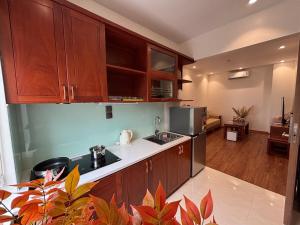 a kitchen with wooden cabinets and a counter top at Mer Suites Ha Long in Ha Long