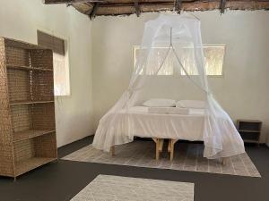 a bedroom with a bed with a mosquito net at Mango Beach Resort in Praia do Tofo