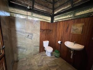 a bathroom with a toilet and a sink at Mango Beach Resort in Praia do Tofo