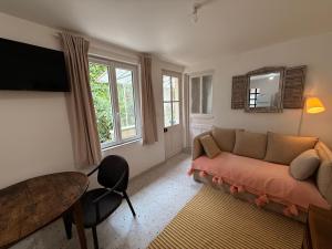 una sala de estar con un sofá y una mesa en L Escapade Cœur de Sologne, en Bracieux