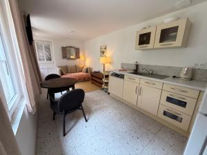Una cocina y una sala de estar con una mesa y un sofá. en L Escapade Cœur de Sologne, en Bracieux