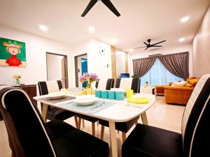 a dining room and living room with a table and chairs at Ipoh Manhattan Free Waterpark 3BR 8Pax Family Suite MHA308 by City Home Empire in Ipoh