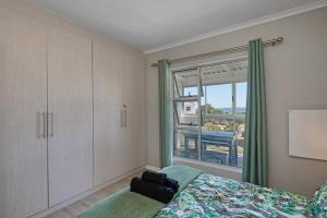 a bedroom with a bed and a window at 61 Big Bay Beach Club in Cape Town +17 photos